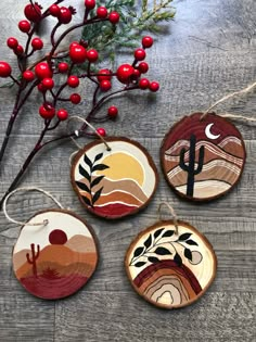 three wooden ornaments are hanging on a table next to some red berries and a branch