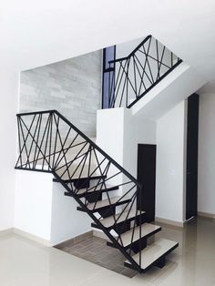 a black and white stair case next to a brick wall in a room with tile flooring