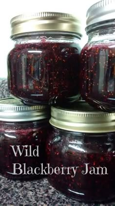 four jars filled with jam sitting on top of a counter