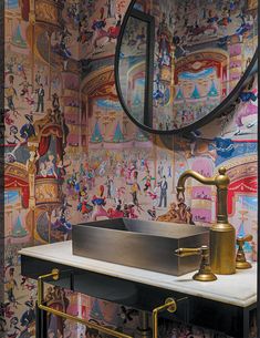 a sink in front of a mirror and wallpaper with disney characters on it's walls