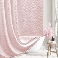 a bath tub sitting next to a pink shower curtain