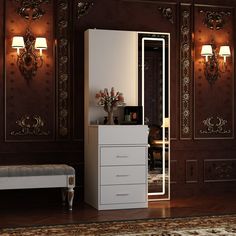 a white dresser sitting next to a mirror on top of a wooden floor in a room