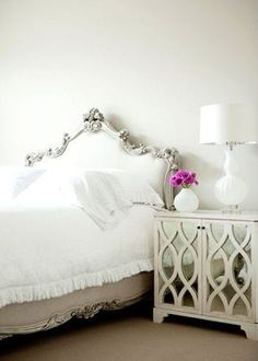 a white bed sitting next to a night stand