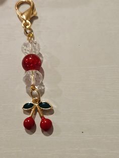 a keychain with two cherries hanging from it's side on a table