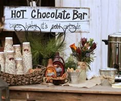 there is a sign that says hot chocolate bar on the table with other items around it