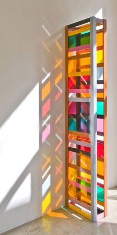 an art piece is shown in the corner of a room with sunlight streaming through it