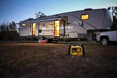 an rv parked in the grass with its lights on