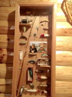 a wooden box filled with lots of different types of fishing lures and other items