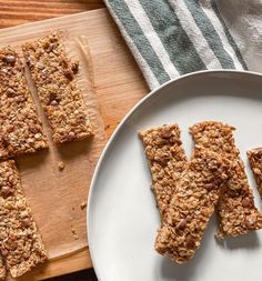 granola bars on a plate next to a cutting board