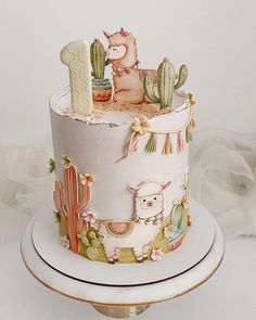 there is a cake decorated with llamas and cactuses on the top tier