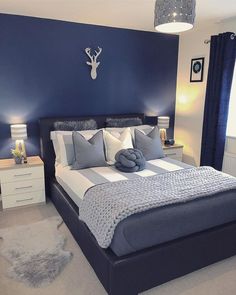 a bedroom with blue walls and white bedding