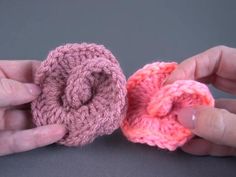 two crocheted pieces of pink and orange yarn being held together by their hands