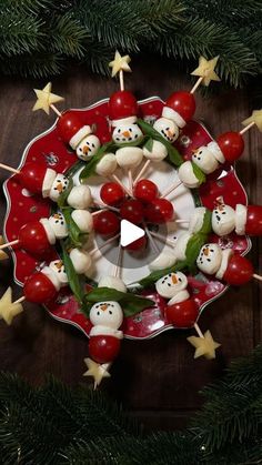 a christmas wreath made out of marshmallows and other holiday decorations on a red plate