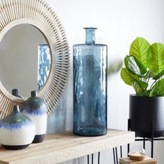 a shelf with vases, mirror and other items on it