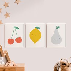 three fruit prints hanging on the wall in a child's room with star decorations