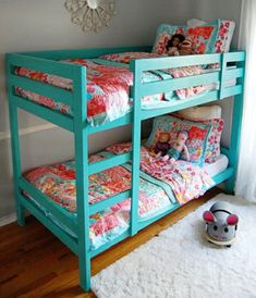 the bunk bed is painted bright blue and has two children's beds on it