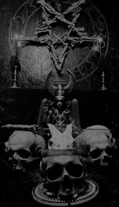 three skulls sitting on top of a table in front of a pentagramus symbol