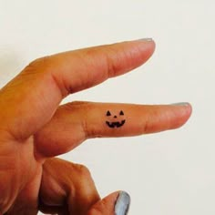 a person's finger with a smiley face drawn on the middle of their thumb