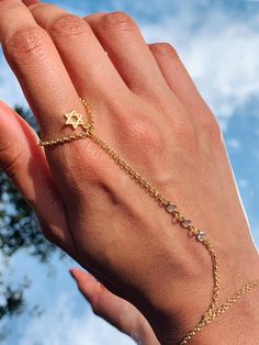 14 Karat Gold Filled CZ Hand Chain with our mini Star of David charm dangling by the ring finger. Bracelet length:  6" + .5" Extension Finger Loop: 2.5"  Hand Chain Piece: 3.75" Material: 18 Karat Gold Filled, Hypoallergenic. Tarnish Resistant. Gold-filled does not de-laminate or peel like Gold plated Jewelry nor does it tarnish as readily as silver. Generally speaking, gold filled is better quality and will have a much longer lasting color than plated jewelry. Gold filled jewelry is an excellent option for those who wish to have a product of exceptional quality, beautiful and anti-allergenic, but with prices far lower than solid gold jewelry. We recommend keeping abrasive chemicals away from the jewelry for the items to last. Thank you for visiting and supporting our small business! We ho David Ring, Hand Chain Bracelet, Dainty Style, Ring Hand, Tiny Star, Bracelet Ring, Alessandra Ambrosio, Hand Chain, Vanessa Hudgens