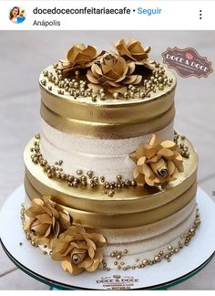 there is a three layer cake with gold flowers on it