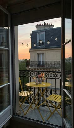 a balcony with two yellow chairs and a table