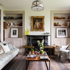 a living room filled with furniture and bookshelves next to a painting on the wall