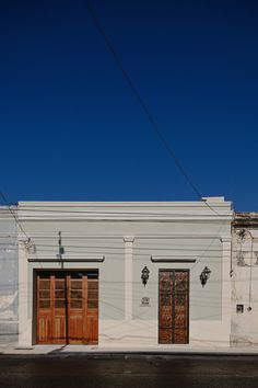 an old white building with two wooden doors