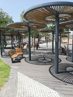 an empty park with benches and umbrellas