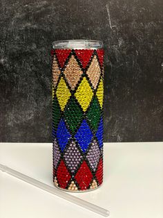 a cup with some beads on it next to a pen