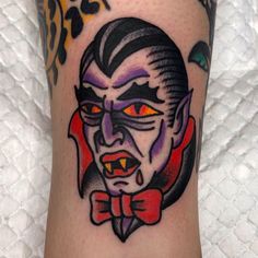 a close up of a person's leg with a tattoo on it and an evil face