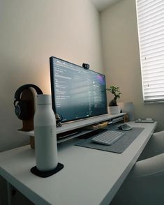 a computer monitor sitting on top of a white desk next to a keyboard and mouse