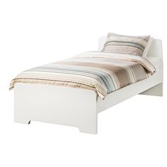 a white bed with a striped pillow on top of the headboard and foot board