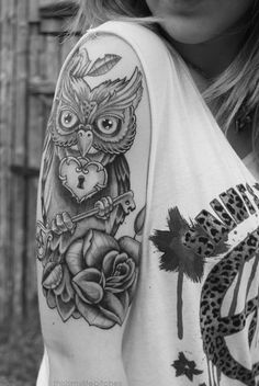 an owl with a key tattoo on his arm holding a heart shaped lock and rose