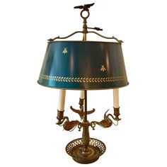 a table lamp with a blue shade and two birds on the top of each light