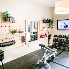 a gym with exercise equipment and a flat screen tv mounted on the wall above it