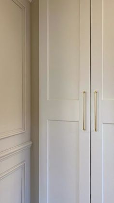 a white closet with two doors and some drawers on the wall next to each other