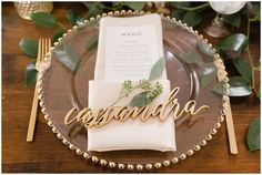 a place setting with napkins, silverware and greenery