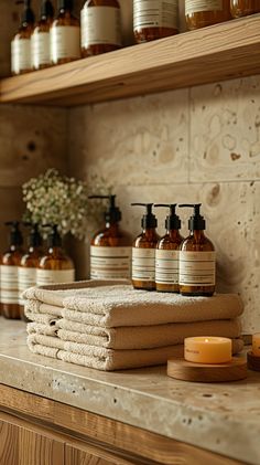 towels, soaps and candles are arranged on the counter in front of wooden shelves