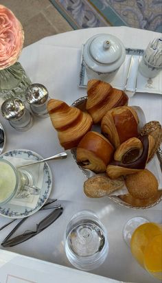 a table topped with lots of pastries on top of a white cloth covered table