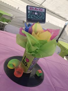 there is a vase with flowers in it on top of a table at a party