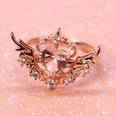 Overcome with love, the happiness and warmth can make anyone’s heart soar! The Camilla Ring - Sunset Pink features a heart-shaped, pastel pink synthetic centre stone with a halo of shining stars and magnificent angel wings at either side. The ring is crafted from sterling silver .925 plated in 14KT rose gold. Please note that with proper care, plated jewelry may need to be replated every 1-2 years. This order will take around 1-2+ weeks to package and process plus additional shipping time. Engagement Rings Pink, Pink Wedding Ring, Cute Promise Rings, Pink Wedding Rings, Sunset Pink, Cute Engagement Rings, S Heart, Girl Jewelry, Fancy Jewelry