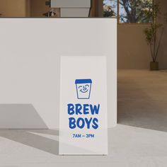 a sign that says brew boys on it in front of a white building with blue lettering