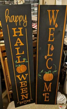 two black and orange welcome signs with pumpkins on them