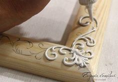 someone is using a carving tool to cut out decorative designs on a piece of wood