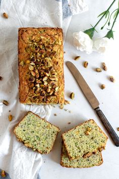 sliced bread with nuts on top next to knife and flowers