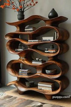 a wooden shelf with books and vases sitting on it's sides in front of a wall