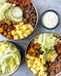 three bowls filled with different types of food next to a bowl of dressing and salad