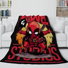 a living room with a couch and a deadpool blanket