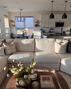 a living room filled with furniture next to a kitchen and dining room table in front of a window