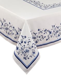 a white tablecloth with blue flowers on it and a border around the edges is shown